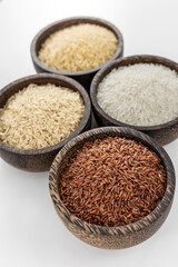 different kinds of asian rice grains in bowls on white background