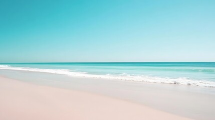 Fototapeta premium Serene beach scene with soft sand and turquoise water under a clear sky.
