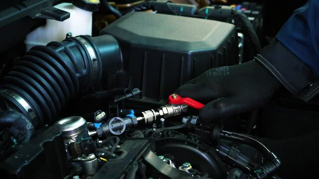 Man Attaching Cables to Recharge Car with Freon
