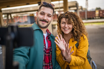 Fototapeta premium couple blogger or v-logger look at camera and talk on train station