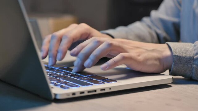 hands typing on laptop keyboard with blue backlight modern workspace tech concept fast data input coding freelance programming night work digital communication