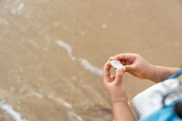 Cheerful adorable little girl having fun outdoor and playing with sand with beach kid toys on the beach in the summer vacation at sunset, happy healthy toddler playful on the tropical seaside.