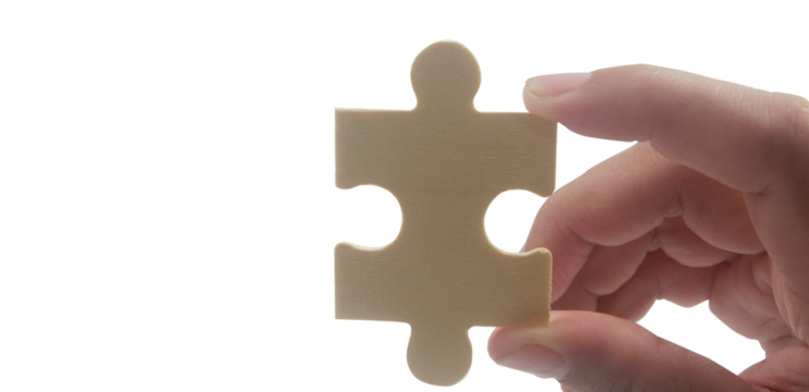 Hand holding puzzle piece close-up conceptual image minimalist background focus on problem solving
