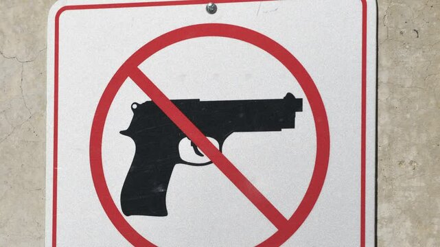 A clear no firearms sign is prominently displayed at Hoover Dam, located on the border of Arizona and Nevada. The sign emphasizes safety regulations for visitors.