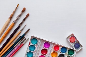 Naklejka premium Creative flat lay of watercolor paints and brushes arranged aesthetically on a clean background