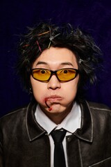 Fashion-forward Asian man showcases vibrant spring style in a creative studio setting