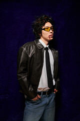 Fototapeta premium Chic Asian man displays modern fashion trends in a vibrant spring studio