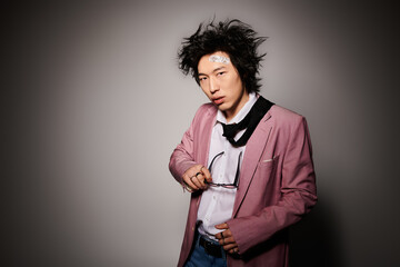 Stylish asian man showcases spring fashion in creative studio setting with unique flair