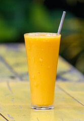 A glass of orange juice sits on a table