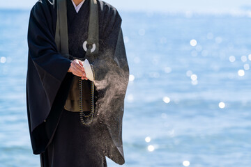 海で僧侶が供養している海洋散骨のイメージ