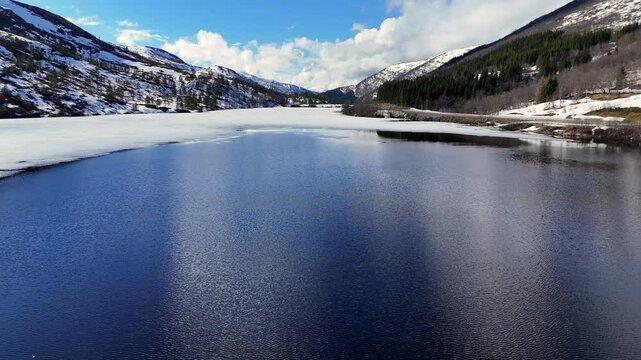 Aerial view of frozen lake Vasslivatnet in the snowy mountains in Norway