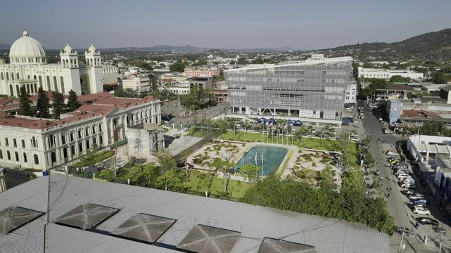 Drone orbits to the right around the southwest corner of Jardin Centroamerica in the late afternoon in downtown San Salvador