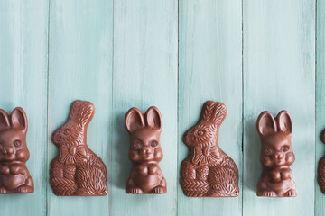 Cute chocolate bunny rabbits over a mint green background. Table top view. Free copy space for text.