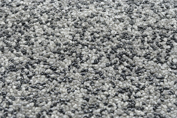 A multitude of wet shiny round pebbles of black, white and grey colour