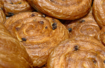 Various types of traditional pastries made from puff pastry - croissants and buns with raisins