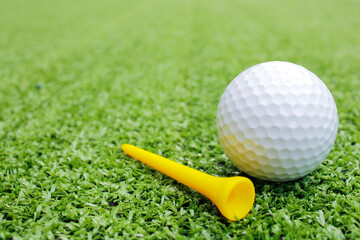 Close-Up View of a Golf Ball and Tee on Green Turf Surface
