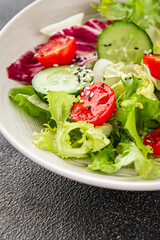Vegetable salad tomato, cucumber, lettuce, green leaf lettuce, onion appetizer vegetable dish fresh gourmet food background rustic food top view copy space 