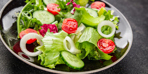 Vegetable salad tomato, cucumber, lettuce, green leaf lettuce, onion appetizer vegetable dish fresh gourmet food background rustic food top view copy space 
