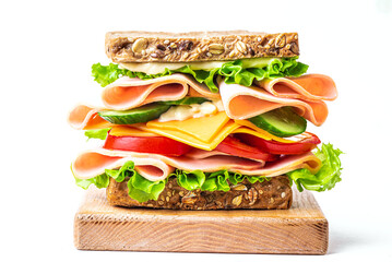 Layered sandwich with ham, cheese and vegetables on white