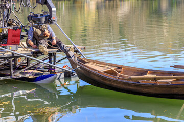Obraz premium A man is sitting on a boat that is being towed by another boat
