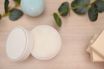 Cosmetic cream, bath salt on a wooden table, white soap, eucalyptus branches.