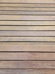 Obraz premium Close-up of a wooden deck floor, with horizontally aligned planks. The natural texture and slight wear provide a rustic and authentic look. Ideal for projects requiring wood background, texture, or ou