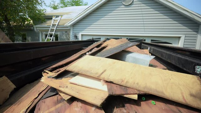 Dumpster with garbage from the old roof. Roofer dismantles old roof covering. installing a new roof on an house. Work elements