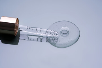 Pipette with serum on a blue background. Product texture.