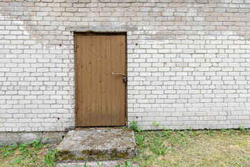 Brown Old Wooden Door Set in a White Brick Wall Exterior
