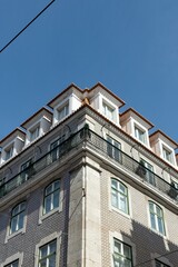 Exterior of an apartment building with balconies against a blue sky 