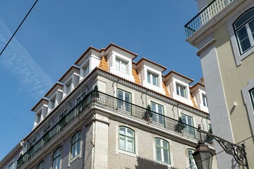 Exterior of an apartment building with balconies against a blue sky 