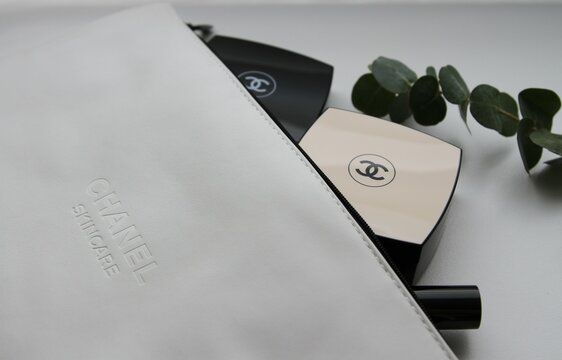 White Chanel cosmetic bag with Chanel cosmetic products and eucalyptus leaves