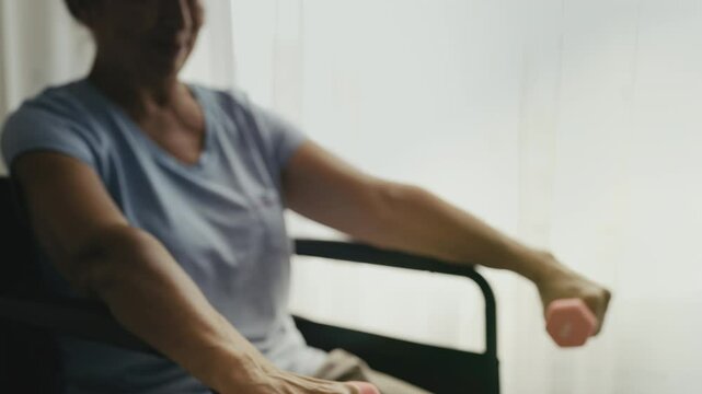 Motivated elderly woman with reduced mobility lifting dumbbells, home workout