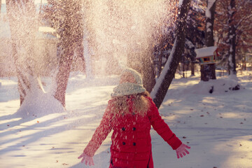  girl throws snow up. New Year and Christmas scene. child in the winter. Winter holidays concept. Blurred photo
