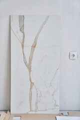 Large rectangular marble wall tiles measuring 120 by 60. On the background of a wall under daylight. High quality photo