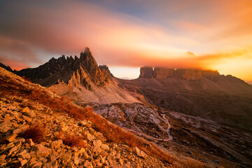 Naklejka premium The iconic Tre cime di lavaredo in the Italian Dolomites at sunset in the clouds. A tourist spot in Italy in autumn colours.