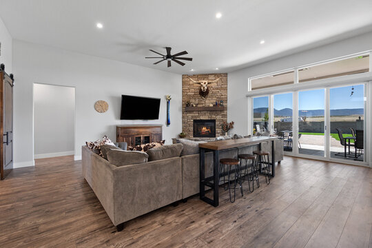 A living room with a couch, TV, fireplace, and sliding doors 