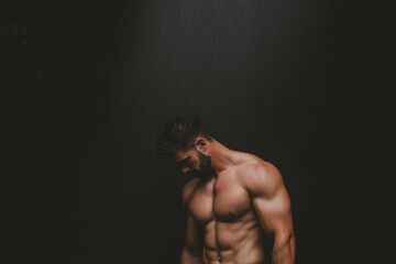 Obraz premium A man with a beard and a muscular chest stands in a dark room