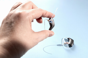 Fototapeta premium Doctor holding modern hearing aid in his hand