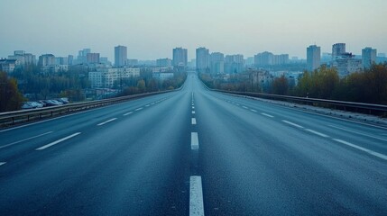 Fototapeta premium A long, empty highway with a city in the background