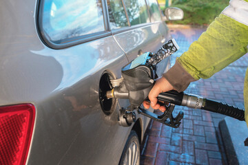 Filling up a car with fuel at a gas station on a sunny day in the countryside