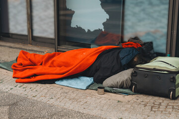 Warm blanket provides comfort to a person sleeping on the street during a chilly day in an urban area