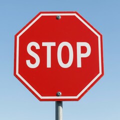 Obraz premium A red stop sign with white lettering against a clear blue sky and metal pole on a sunny day