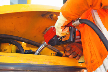 Close-up of builder refueling heavy machinery with diesel fuel at  construction site © Iryna