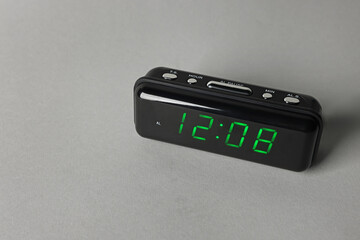 Digital alarm clock showing 12:08 o'clock on grey background, space for text