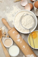 Rolling pin and different ingredients on light table, flat lay