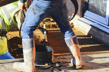 Builder leveling sand bed for concrete paving slab installation