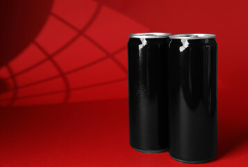 Two tin cans on red background with shadow. Space for text