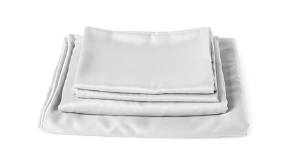 Stack of silky bed linens on white background