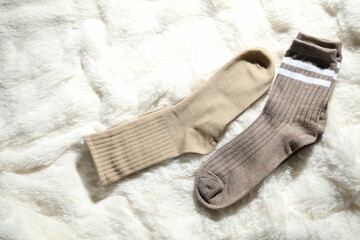 Soft socks on white faux fur, top view